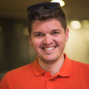 photo of smiling employee in orange shirt